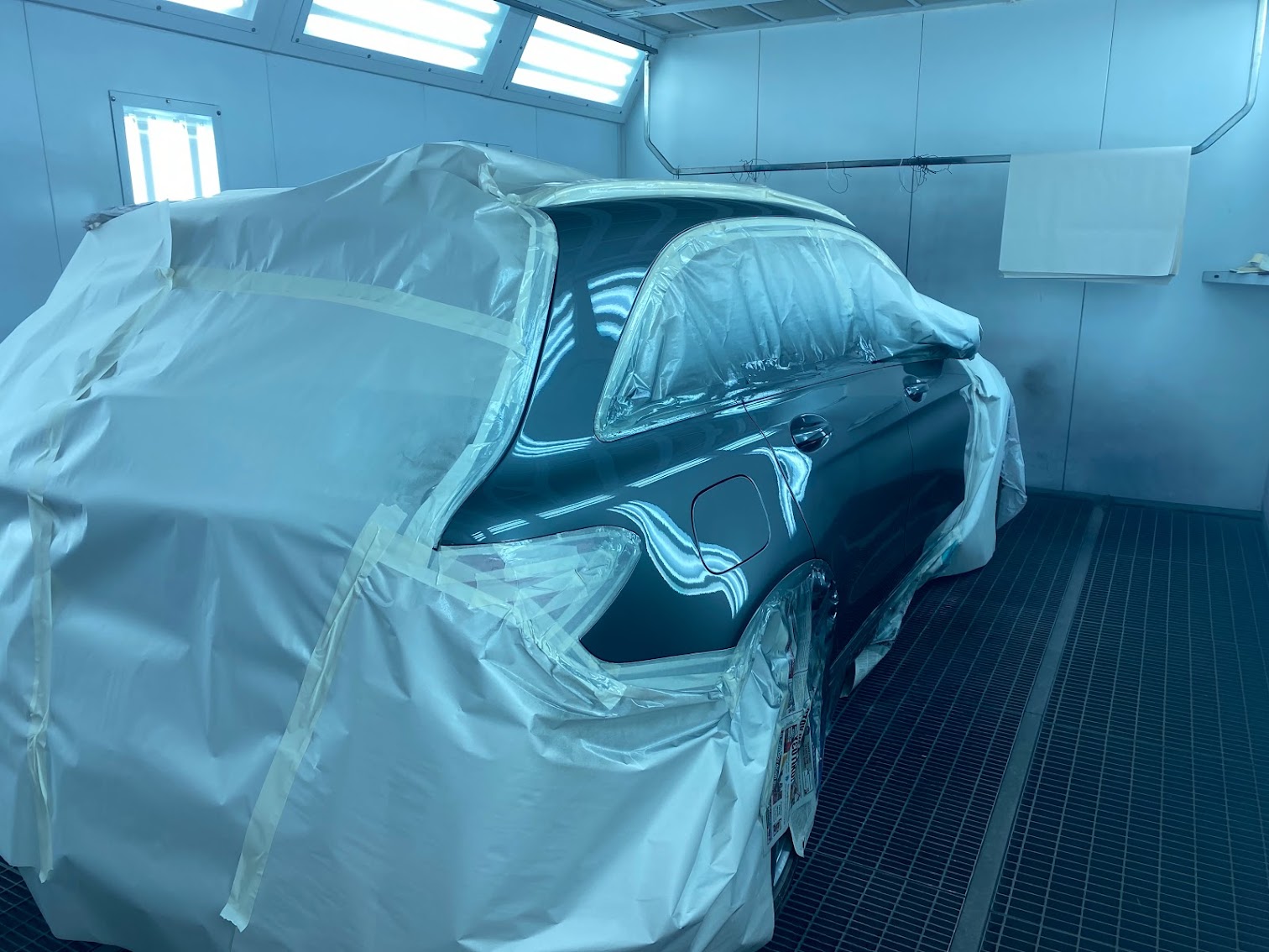Green car masked and prepped in paint booth